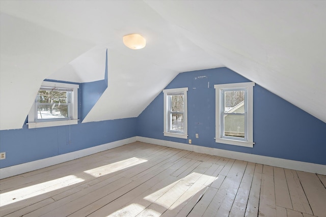 bonus room with vaulted ceiling, light hardwood / wood-style flooring, and a wealth of natural light