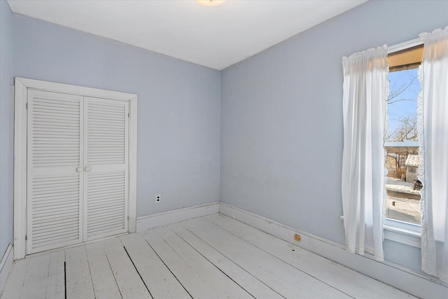 unfurnished bedroom with a closet and light hardwood / wood-style flooring