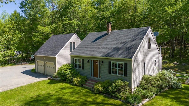 cape cod house with a front yard and a garage