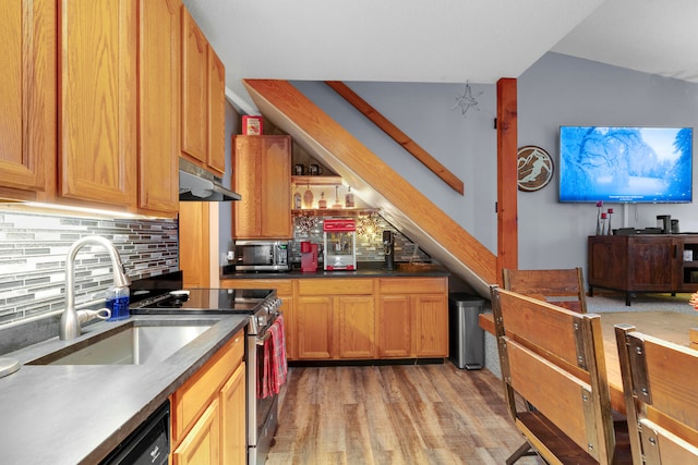 kitchen with sink, stainless steel appliances, light hardwood / wood-style flooring, backsplash, and vaulted ceiling