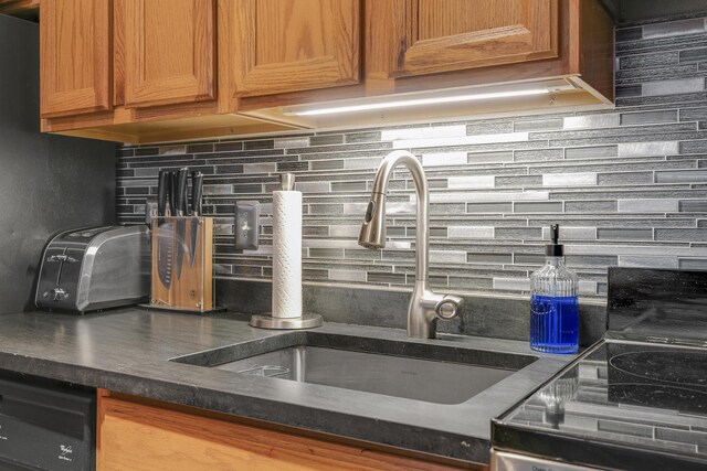 8 Sunrise Dr Unit C122, Newry, ME 04261 - kitchen featuring a sink, tasteful backsplash, dark countertops, and brown cabinets
