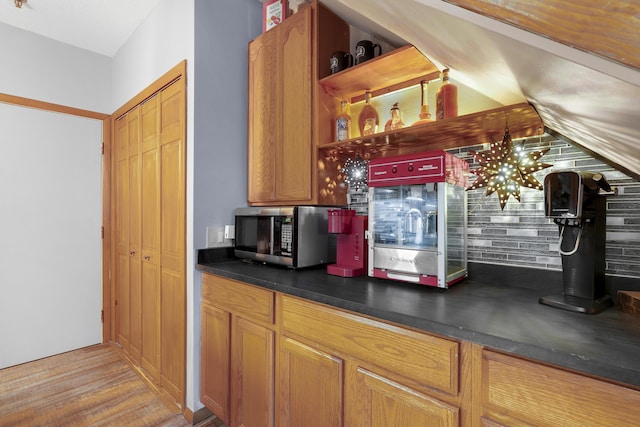 8 Sunrise Dr Unit C122, Newry, ME 04261 - kitchen featuring stainless steel microwave, dark countertops, open shelves, brown cabinetry, and wood finished floors