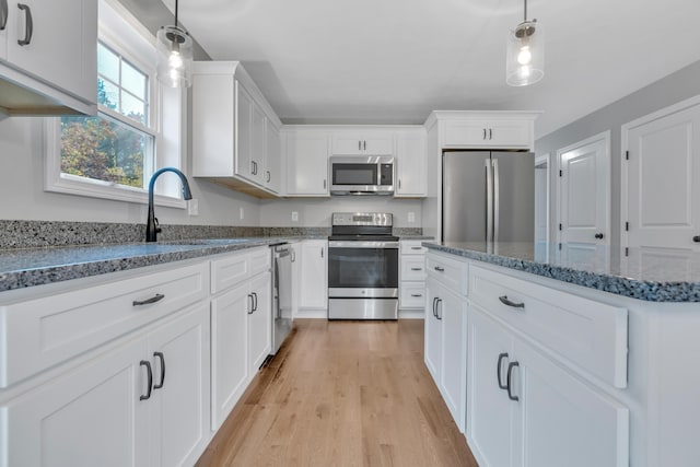 kitchen featuring white cabinets, sink, light wood-type flooring, and stainless steel appliances