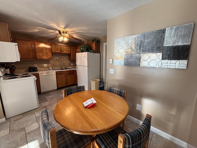 dining space with a textured ceiling, ceiling fan, and sink