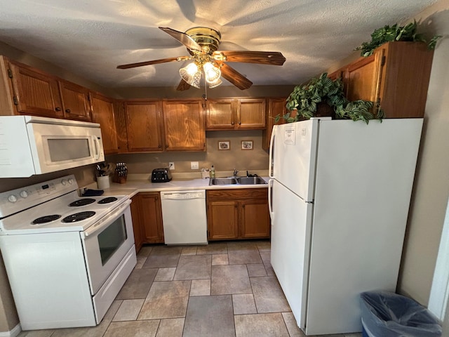 kitchen featuring ceiling fan, sink, white appliances, and a textured ceiling