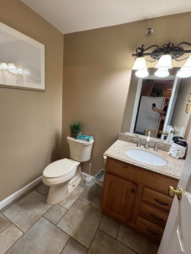 bathroom featuring tile patterned floors, vanity, and toilet