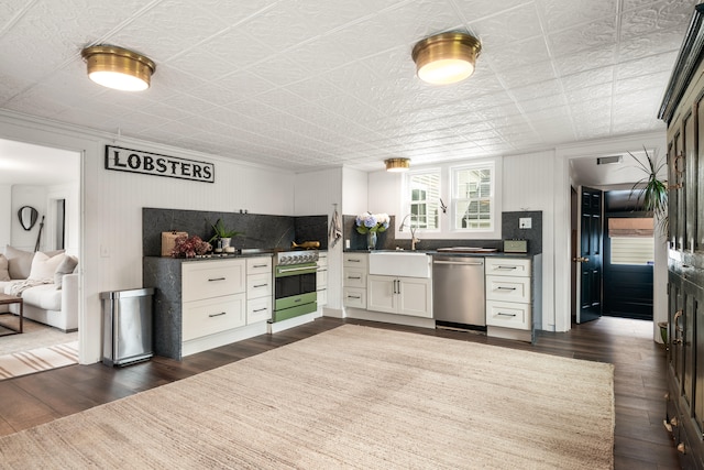 kitchen with tasteful backsplash, stainless steel appliances, dark wood-type flooring, sink, and white cabinets