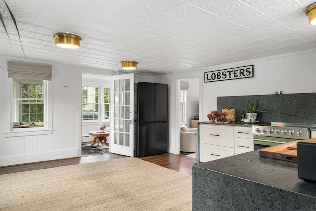 kitchen with white cabinets, backsplash, dark hardwood / wood-style floors, and high end stainless steel range oven