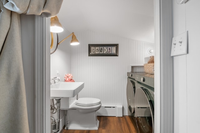 bathroom featuring hardwood / wood-style floors, a baseboard heating unit, sink, vaulted ceiling, and toilet