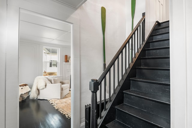 stairway with hardwood / wood-style floors and ornamental molding