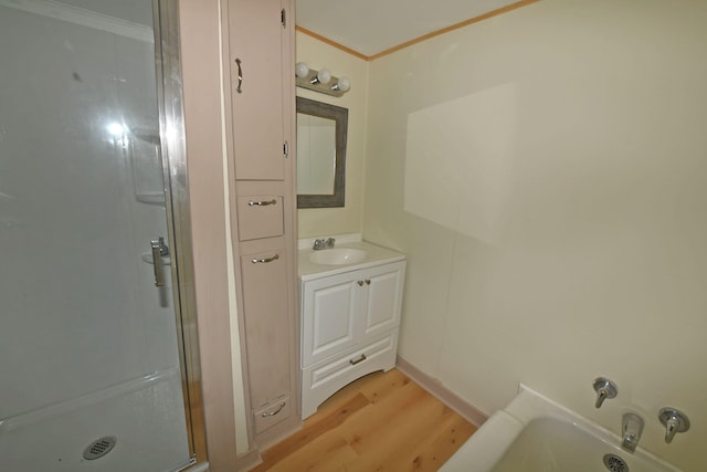 bathroom featuring vanity, crown molding, wood-type flooring, and walk in shower