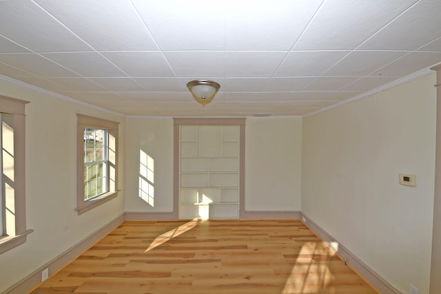 empty room featuring light hardwood / wood-style floors and crown molding