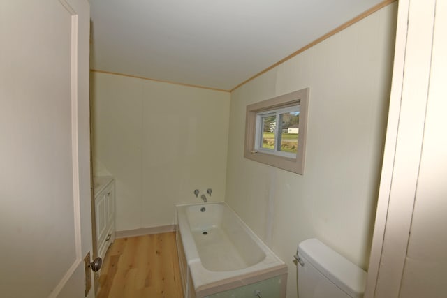 bathroom with vanity, a bathing tub, crown molding, toilet, and wood-type flooring