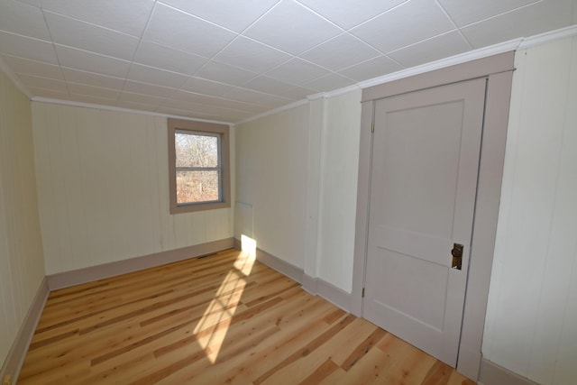 unfurnished room featuring light hardwood / wood-style flooring and crown molding