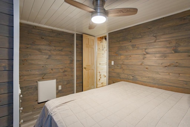 bedroom with ceiling fan, wooden ceiling, and wood walls