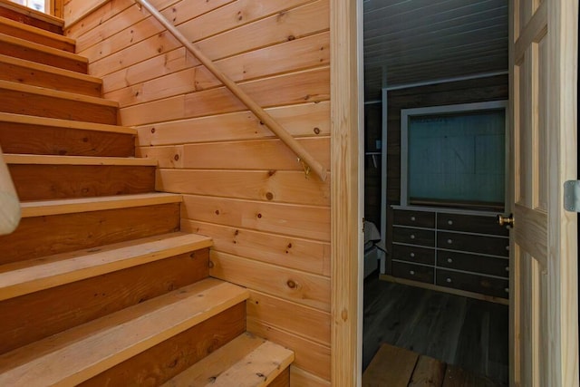 stairway with wood-type flooring and wooden walls