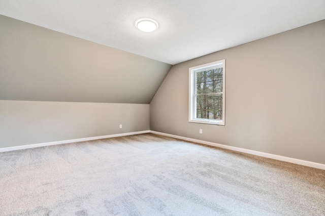 additional living space with carpet flooring and lofted ceiling