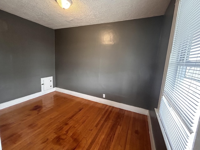 spare room with a textured ceiling and hardwood / wood-style flooring