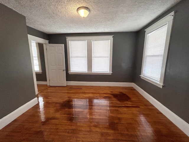 spare room with wood-type flooring and a textured ceiling