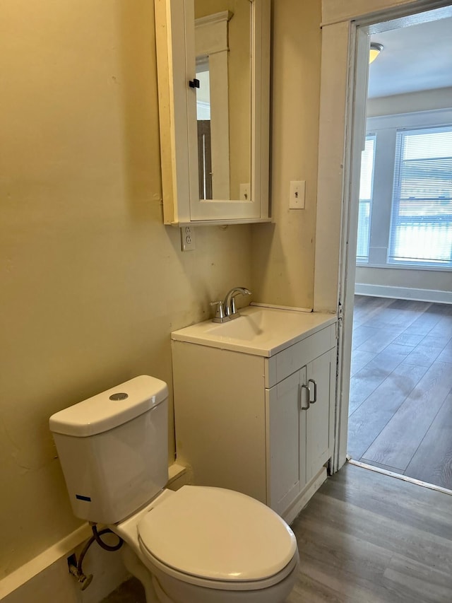 bathroom with toilet, vanity, and hardwood / wood-style flooring