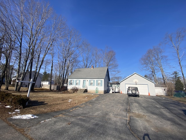 new england style home featuring an outbuilding and a garage