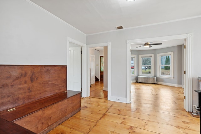 unfurnished room with light hardwood / wood-style flooring, radiator, ornamental molding, and ceiling fan