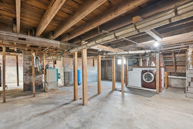 basement featuring washer and dryer and brick wall