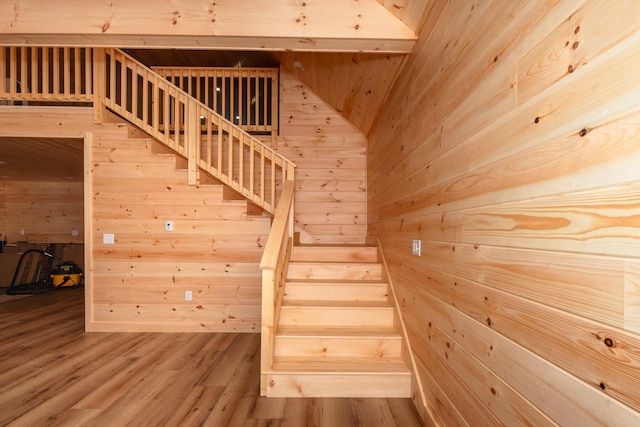 stairs with hardwood / wood-style floors and wood walls