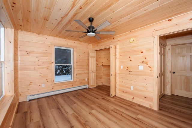 spare room with wood walls, a baseboard heating unit, and wood ceiling