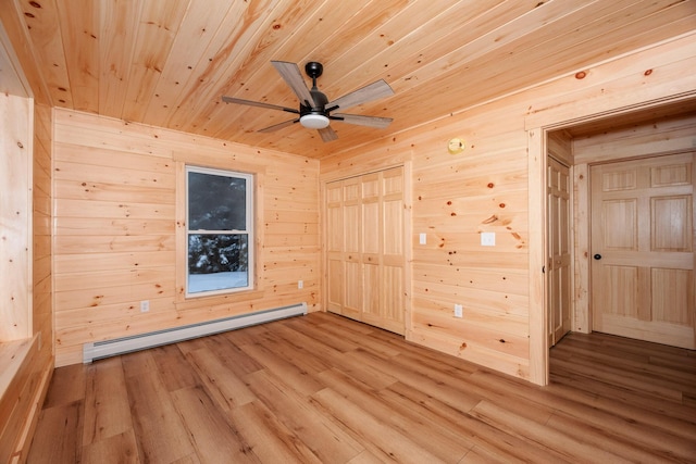 empty room with wood ceiling, wood walls, hardwood / wood-style floors, and baseboard heating