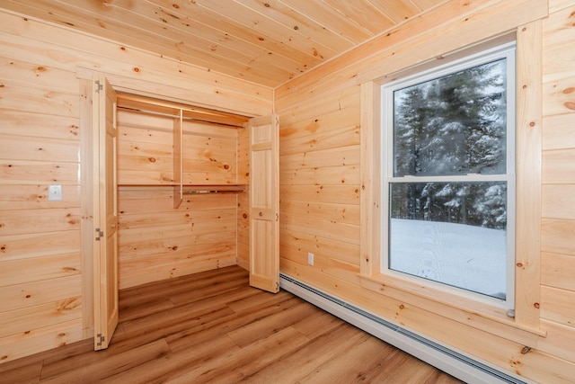 interior space featuring wood ceiling, wooden walls, baseboard heating, and wood-type flooring