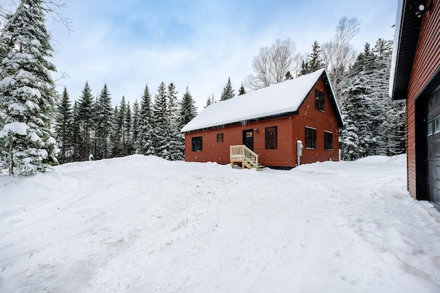 view of snowy exterior with a detached garage