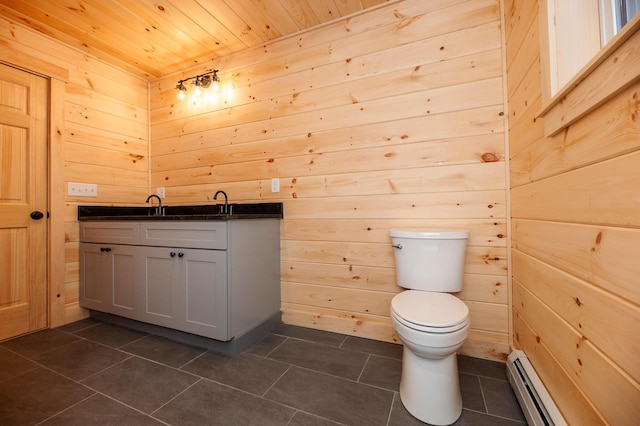 bathroom with toilet, wood ceiling, a baseboard heating unit, wooden walls, and vanity