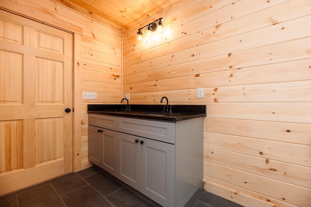 bathroom with wooden ceiling, wooden walls, tile patterned floors, and vanity