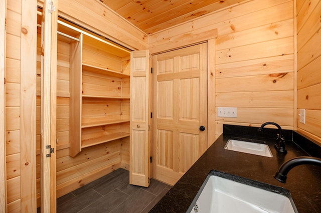 bathroom featuring sink, wood walls, and wooden ceiling