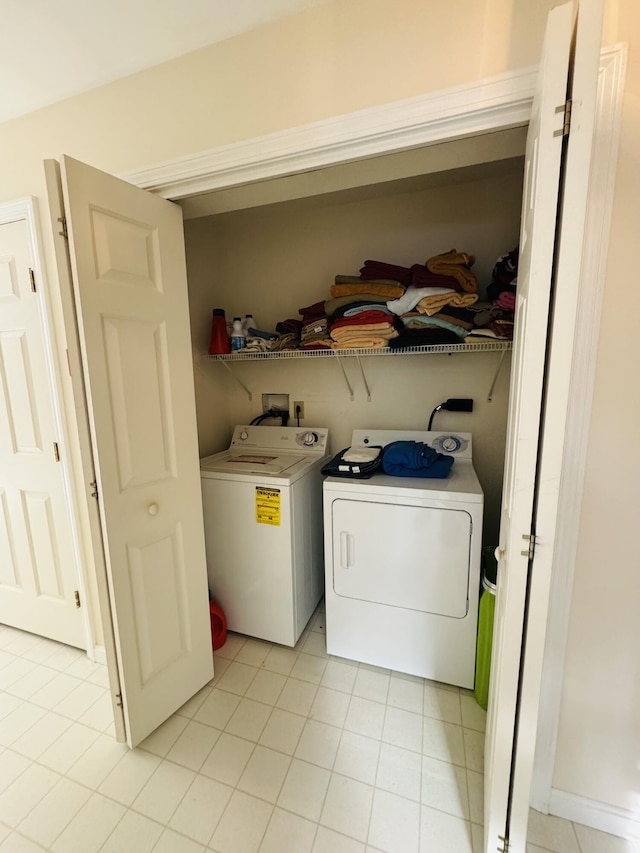 laundry room featuring light tile patterned floors, laundry area, and washing machine and dryer