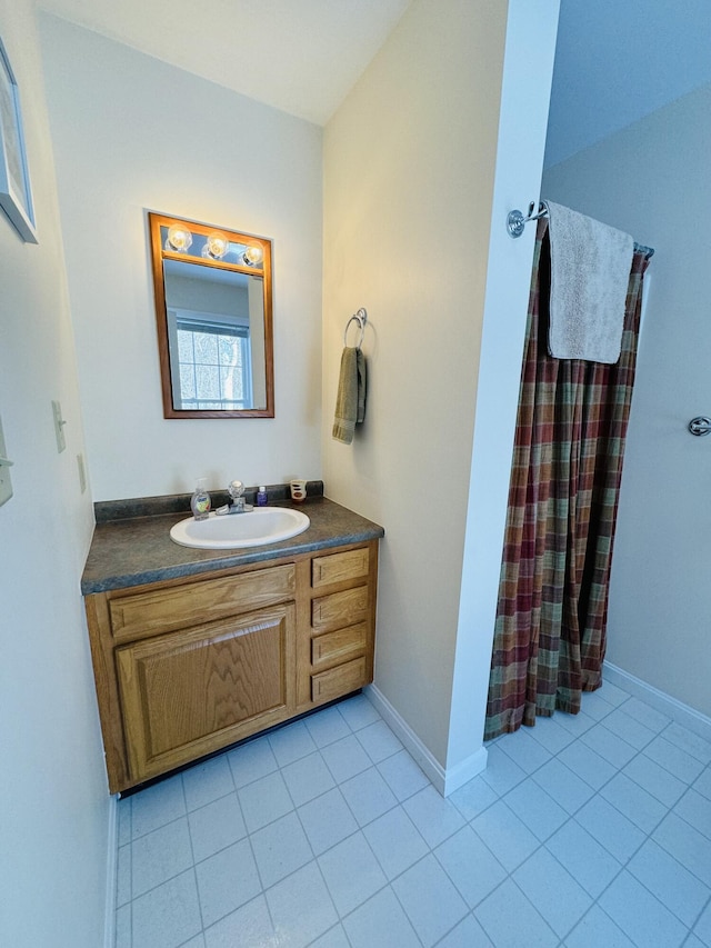 full bathroom with tile patterned flooring, vanity, and baseboards