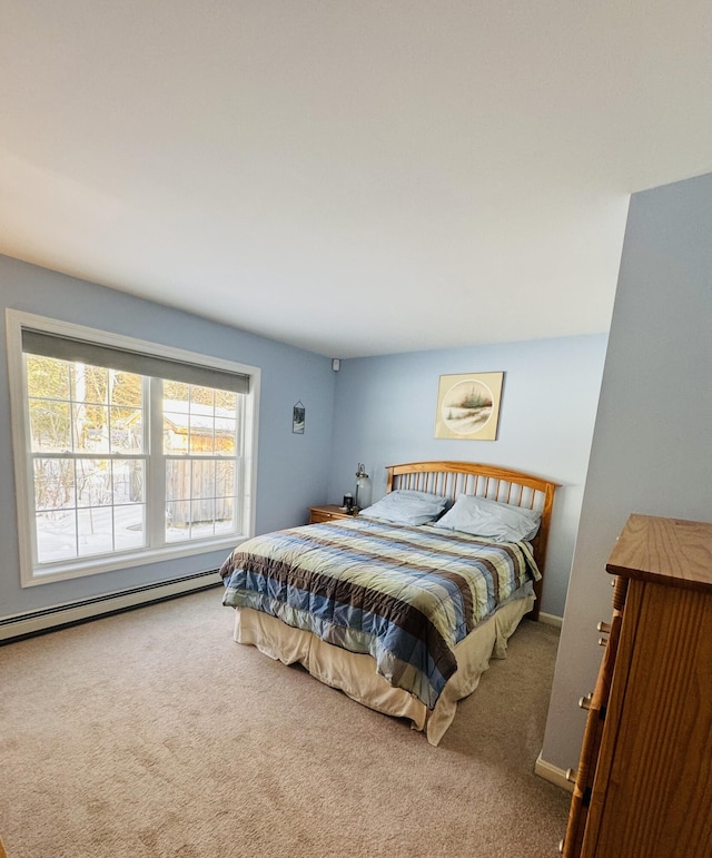 carpeted bedroom with a baseboard heating unit and baseboards