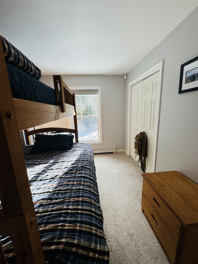 carpeted bedroom with a baseboard heating unit, baseboards, and a closet