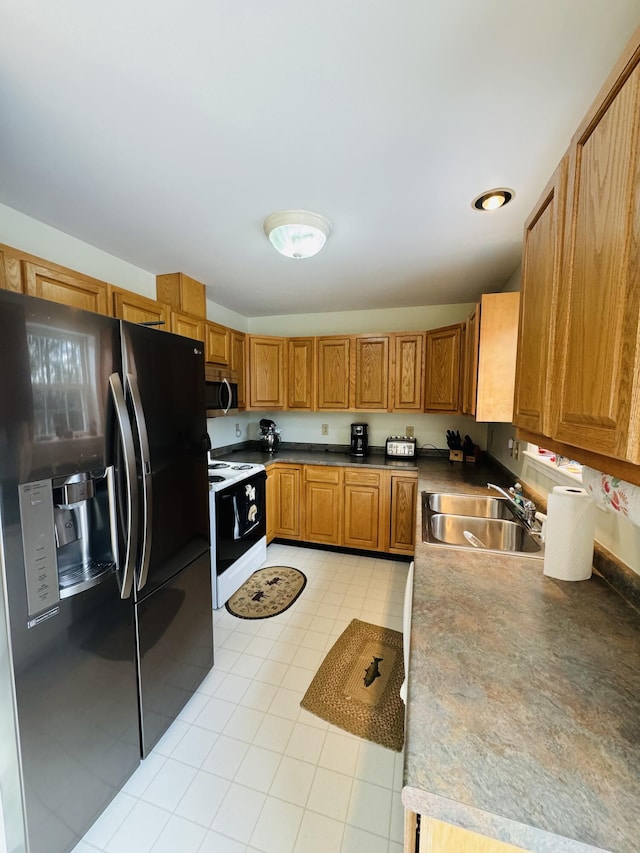 kitchen with white range with electric cooktop, black fridge, and sink