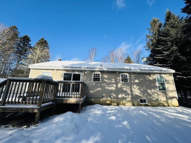 snow covered back of property featuring a wooden deck