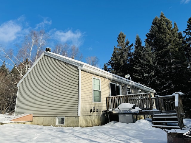 view of snowy exterior featuring a wooden deck