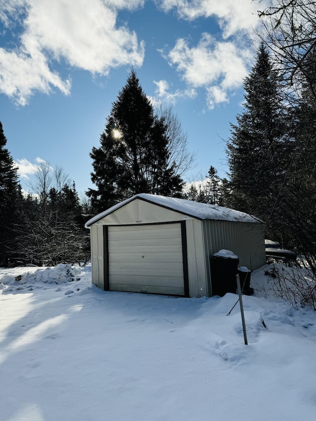 snow covered garage with a garage