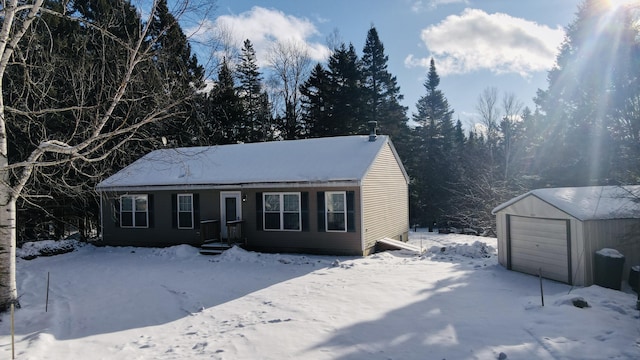 view of front facade with a detached garage and an outbuilding