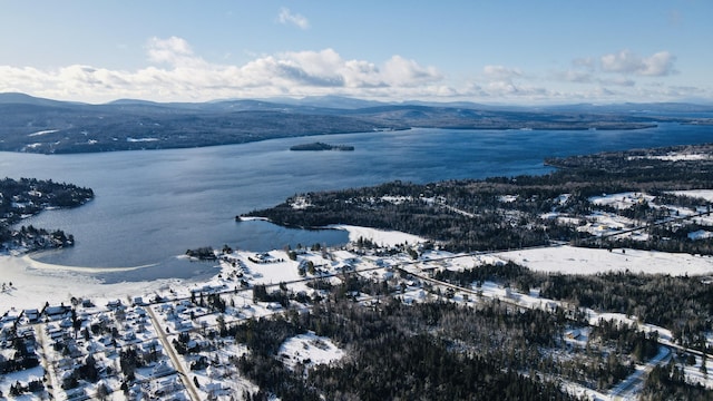 snowy aerial view featuring a water and mountain view