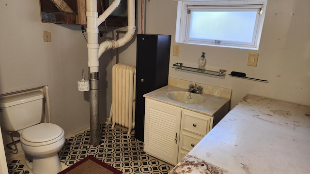 bathroom with vanity, toilet, and radiator