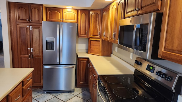 kitchen with light tile patterned floors and stainless steel appliances