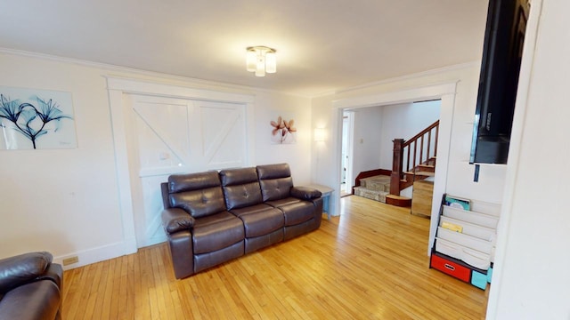 living room with light hardwood / wood-style floors and ornamental molding