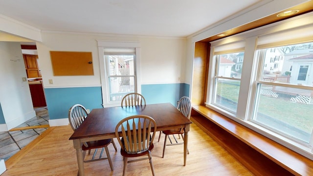 dining area featuring light hardwood / wood-style floors and ornamental molding