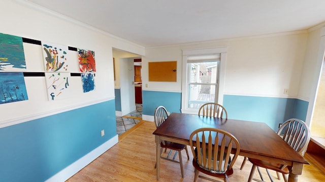 dining area with light wood-type flooring and crown molding